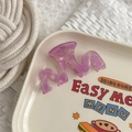 Close-up of a wavy purple translucent acetate hair claw clip on a decorative tray - Rose Red