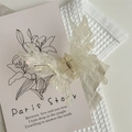 Macro detail of butterfly hair claw clip with sparkling glitter and resin texture - Pearl White