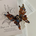 Détail d'une pince à cheveux papillon avec texture marbrée brune et bleue sur tissu - Bleu Lac Café