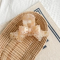 Macro detail of peach marble textured bow hair claw clip with delicate lace hollow edges - Pale Green