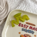 Close-up of bright green wavy acetate hair claw clip on a decorative vintage plate - Green Stripe