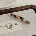 Detailed close-up of tortoise shell acetate hair clip with golden metallic logo lettering - Light Leopard