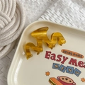 Detailed view of the amber wavy acetate hair claw clip on a vintage ceramic plate - Yellow Stripes