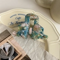 Detail of marble pattern hair claw clip with colorful resin and metal spring on a plate - Pale Blue