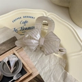 Detailed view of striped bow hair claw with VD logo on a ceramic tray for thin hair - Grey Stripe