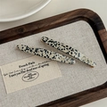 Detail of tortoiseshell pattern hair clips with gold logo on a wooden tray - Black Polka Dot (With Card)