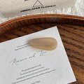 Detailaufnahme der beigen Marmor-Haarspange mit dem FRANCE Handmade-Schriftzug darauf - Gestreiftes Beige