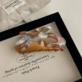 Detail of large acetate hair claw clip with tortoise texture on a French style tray - Dunhuang Pattern And Orange