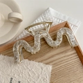 Detail showing marble wave hair claw clip on wooden tray with cozy minimalist background - Cream Gray