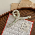 Detailed macro view of an elegant cream and green marble acetate hair claw with gold frame - Light Green Marble