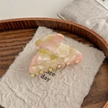 Detalle de una pinza para el pelo de acetato jaspeado con letras doradas Barrette La France - Floral Rosa Verde