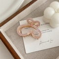 Detail of a pink gradient butterfly hair claw clip with pearls on a wooden tray - Pink
