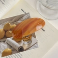 Close-up of amber marble textured hair clip on a vintage magazine lifestyle setting - Caramel color