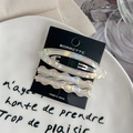 Detailed view of 3-piece acetate hair clips with pearlescent finish on a display card - Iridescent White (Wavy And Oval Clip Set)