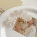Detailed close-up of iridescent pearl white wavy hair claw clip on elegant ceramic plate - Mermaid Color