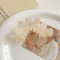 Close-up of a large cream marble acetate hair claw clip with shell-like texture details - Creamy Yellow Marble
