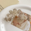 Detail of large acetate hair claw clip with marble texture on a ceramic plate - Beige Purple Marble