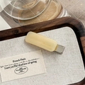 Macro shot of French acetate barrette in cream yellow with metal clip and engraving - Beige