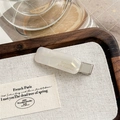 Detail of cream acetate hair clip with gold lettering on a rustic linen background - Pearl White