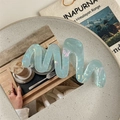 Close-up of a large wave-shaped hair claw clip in iridescent pearly light blue finish - Iridescent Blue-Green (11cm)