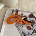 Detailed view of the bright orange and tortoiseshell butterfly hair claw on a ceramic tray - Stone Flower and Orange (Exquisite Packaging)