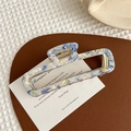 Dettaglio del mollettone rettangolare in acetato con trama marmo blu e molla in metallo oro - Blu