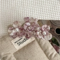 Detail of purple marble acetate hair claw clip featuring three floral designs with pearls - Purple