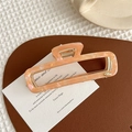 Detail of pink marble acetate hair claw clip with rectangular hollow design and gold spring - Pale Green