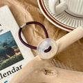 Close-up of durable purple elastic hair tie with a shimmering iridescent round button charm - Pearl White