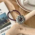 Detail of high-elastic purple hair tie with vintage speckled resin button on wood - Black And White Spots