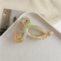 Detail of colorful marble acetate hair claw clip with golden logo and metal spring - AB Color