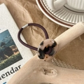 Close-up of a high-elastic purple hair tie with a round amber tortoiseshell resin button - Light Leopard