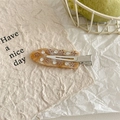 Detail view of amber marble acetate hair clip with pink rhinestone flower inlay and silver metal grip - Yellow