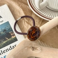 Close-up of durable purple elastic hair tie with tortoiseshell acrylic button detail - Lake Blue Brown