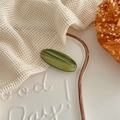 Detailed view of handmade olive green acetate hair clip with gold lettering on a tray - Green Striped