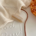 Detail of oval acetate hair clip with marble texture on a white ceramic plate - Striped Beige