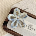 Dettaglio della molletta per capelli a fiore in acetato con trama marmorizzata e molla - Blu Chiaro