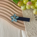 Detailed view of translucent blue floral hair clip on a minimalist wooden tray - Blue Flower Blue Base