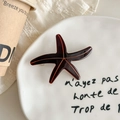 Detail view of a vintage dark brown starfish hair clip on elegant decorative porcelain - Dark Coffee