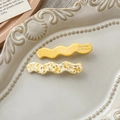 Detail von gelben und schildpatt Acetat-Wellen-Haarspangen mit Goldschrift auf einem Teller - Gelbe Flecken Und Gelb