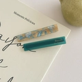 Detail von marmorierten und durchscheinenden grünen Acetat-Haarspangen auf Buch - Gelb Blau + Blau