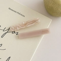 Nahaufnahme von marmorierten Acetat-Haarklammern auf einem Buch für einen französischen Retro-Look - Naturweiß + Weiß