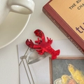 Détail d'une pince à cheveux en forme de homard rouge en résine d'acétate marbré - Homard