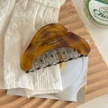 Detailed view of large tortoiseshell hair claw clip with Barrette La France printing - Caramel color