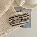Detailed close-up of a large marbled acetate hair claw with gold MY metal emblem - Beige Black Stripes