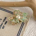 Macro view of floral hair claw clip with pearl center and green marble resin detail - Pale Green