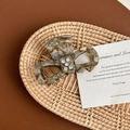 Detail of tortoise shell acetate hair claw with rhinestones on woven tray - Streamer Brown (YD1136)