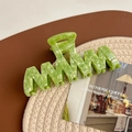 Macro detail of a large wavy light green acetate hair claw clip with a marble texture - Grass Green