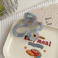 Détail de la pince papillon en acétate bleu-violet avec logo métallique gravé - Bleu Pâle