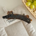 Detail der Bananenspange mit Schildpattmuster, Katzen-Design und goldenem Frankreich-Logo - See Blau Braun
